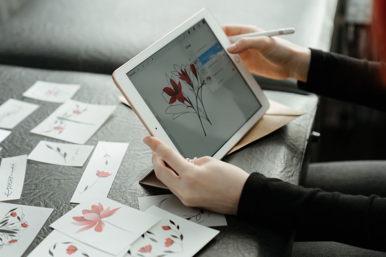 An artist creating floral illustrations on a tablet with a stylus